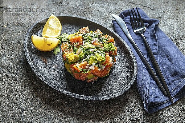 Food  Food  PERUVIAN NIKKEI FOOD. Salmon avocado ceviche on black plate  black background top view