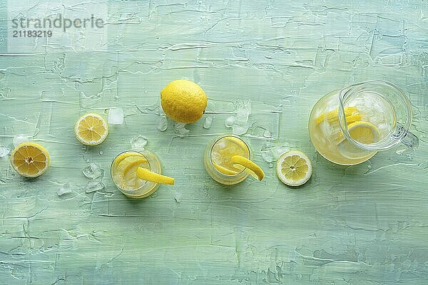 Limonade. Zitronenwasser Getränk mit Eis. Zwei Gläser und ein Krug auf einem blauen Hintergrund  Overhead Flat Lay Shot mit Kopie Raum. Entgiftungsgetränk. Frische hausgemachte Cocktails  Lebensmittel Fotografie