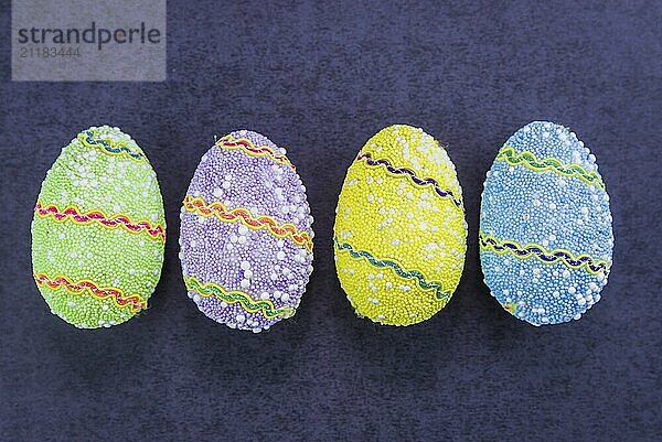 Colorful Easter eggs lined up side by side on a trendy black background