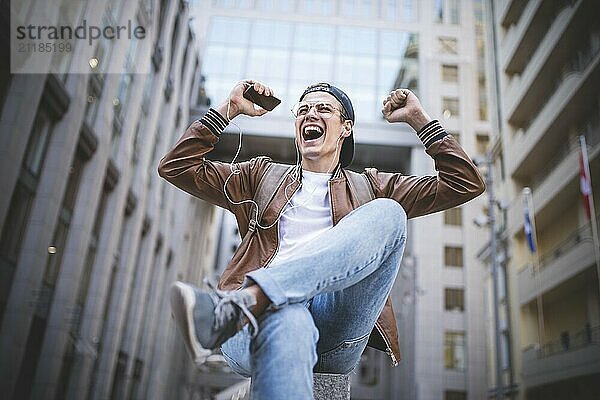 Man Sitting Listening Music Earphones Concept. Cheerful young guy listening the music