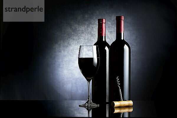 Wineglass and two bottles of wine on a black background