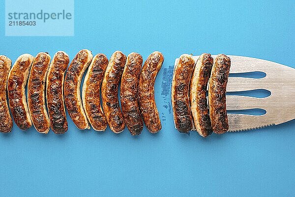 Above view with grilled bavarian bratwurst on blue background. Delicious german bratwurst