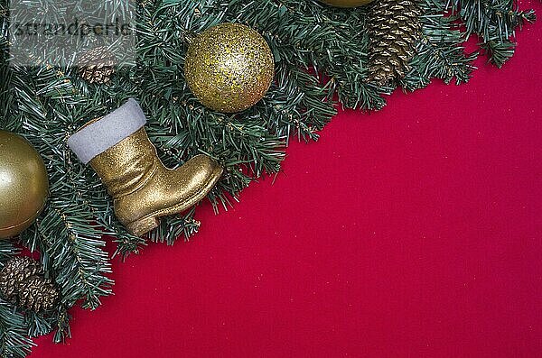 Texture with Christmas theme with green leaves  decorative objects and red background. With copy space