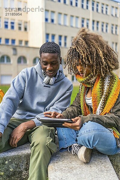 Millennial diverse student friends studying for an exam using digital tablet before going into classroom