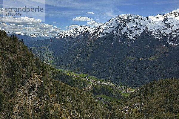 Beautiful top view of high snow-covered mountains and valley with road and village in Switzerland