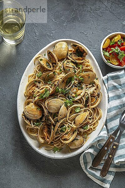 Food  Food  Seafood Pasta. ITALIAN SPAGHETTI ALLE VONGOLE. Clams spaghetti on white plate with white wine  gray background. Top view