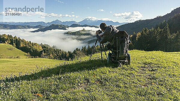 Man on wheelchair taking photos of beautiful landscape