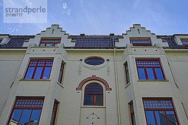 Bright Art Nouveau building facade with red windows and blue sky in the background  Bergen  Vestland  Norway  Europe