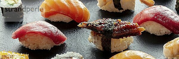 Sushi Panorama. Nigiri mit Aal  Thunfisch  Lachs auf schwarzem Hintergrund  Japanisches Essen auf einem Teller in einem asiatischen Restaurant  Food Fotografie