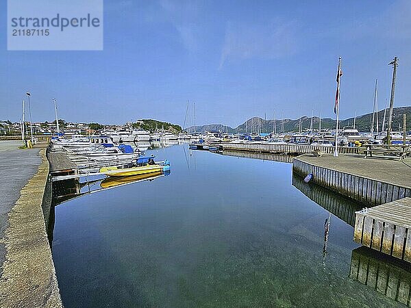 A quiet harbour with boats on a jetty  surrounded by mountains under a blue sky  Sandnes  Fylke Rogaland  Norway  Europe