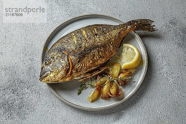 Food  Food  Grilled sea bream or dorada on gray plate. Gray background