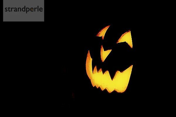 Leuchtendes Kürbisgesicht  Halloween  vor schwarzem Hintergrund