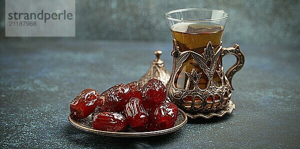 Fastenbrechen mit getrockneten Datteln während des Ramadan Kareem  Iftar Mahlzeit mit Datteln und arabischem Tee im traditionellen Glas  Blickwinkel auf rustikalem blauen Hintergrund. Muslimisches Festmahl  Foodfotografie  food photography  food photography