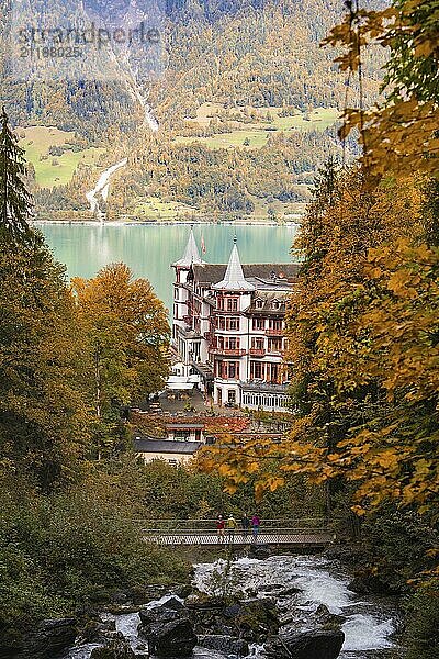 Blick auf ein Gebäude am Ufer eines Sees  eingefasst von herbstlichem Wald  Brienzer See  Schweiz  Europa