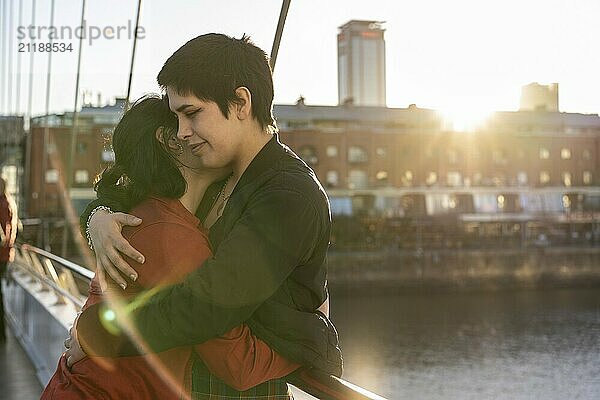 Young LGBT couple of women embracing each other on a bridge  creating a moment of love with ample copy space