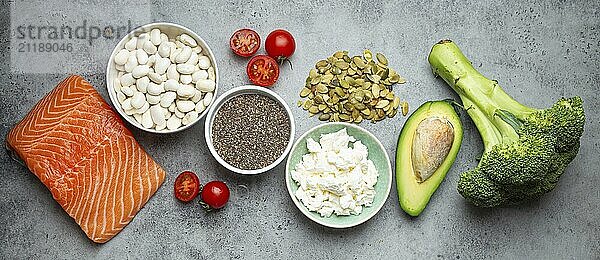 Auswahl an gesunden Lebensmitteln  wenn eine Person Diabetes hat: Lachsfisch  Brokkoli  Avocado  Bohnen  Gemüse  Samen auf grauem Hintergrund von oben. Gesunde Diabetes Diät  Lebensmittel Fotografie  food photography  food photography