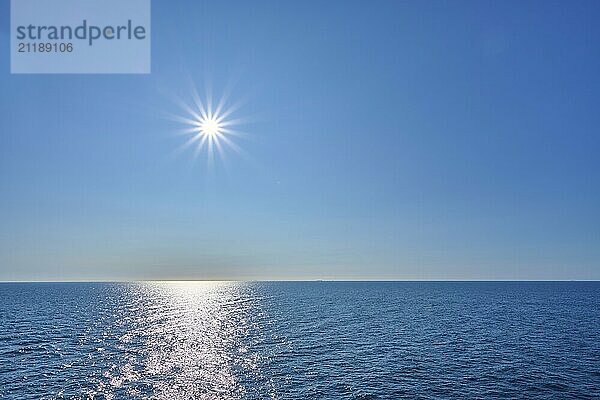 Clear sea under a bright sun and blue sky  calm atmosphere with a wide horizon  North Sea  Norway  Europe