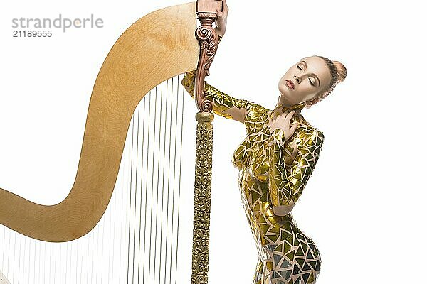 Sexy girl with gold tape body art cropped isolated view with a luxurious musical harp