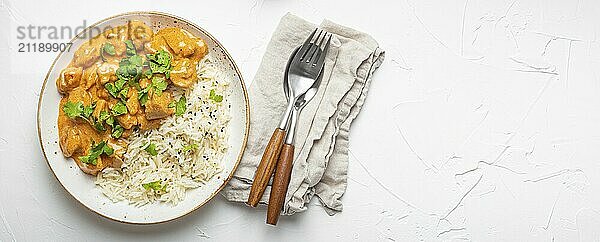 Traditionelles indisches Gericht Hühnercurry mit Basmatireis und frischem Koriander auf rustikalem weißen Teller auf weißem Betontisch Hintergrund von oben. Indisches Abendessen  Platz für Text  Food Fotografie  food photography  food photography