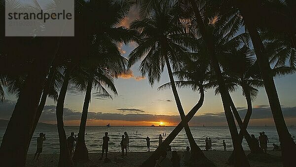 Silhouetted Menschen und Palmen am Meer. Sonnenuntergang am tropischen weißen Strand  Insel Boracay  Philippinen  Asien