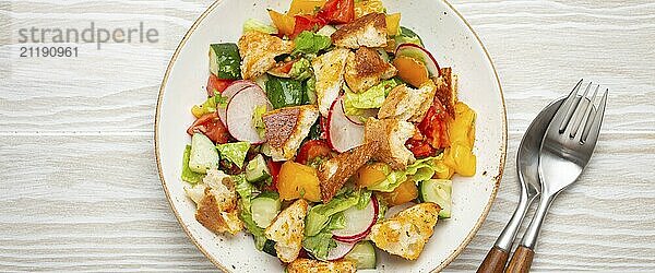 Traditionelle Levante Gericht Fattoush Salat  arabische Küche  mit Fladenbrot Croutons  Gemüse  Kräuter. Gesunder vegetarischer Salat aus dem Nahen Osten  rustikaler hölzerner weißer Hintergrund von oben  Lebensmittel Fotografie  food photography  food photography