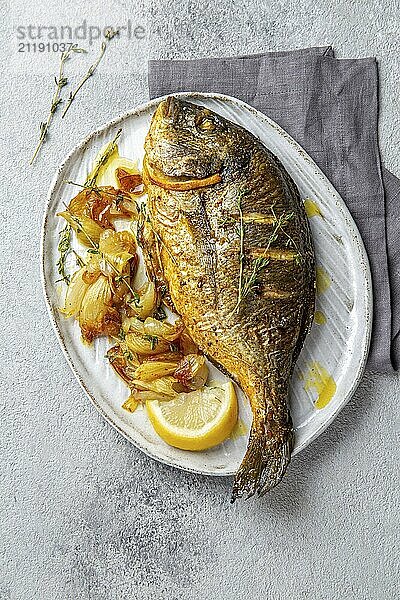 Food  Food  Grilled sea bream or dorada on gray plate. Gray background