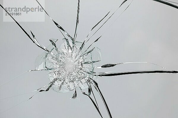 Broken window with cracks from impact or shot. Texture of cracks and chips on car windshield  concept for design on white background