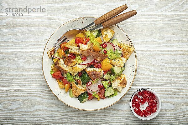 Traditionelle Levante Gericht Fattoush Salat  arabische Küche  mit Fladenbrot Croutons  Gemüse  Kräuter. Gesunder vegetarischer Salat aus dem Nahen Osten  rustikaler hölzerner weißer Hintergrund von oben  Lebensmittel Fotografie  food photography  food photography