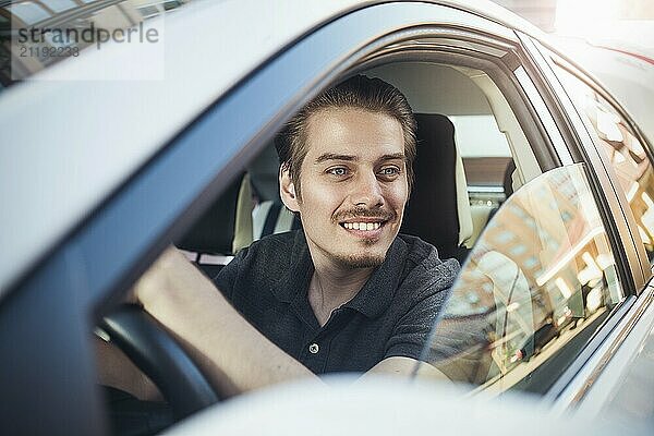 Enjoy the drive. Image of young handsome guy sitting in car