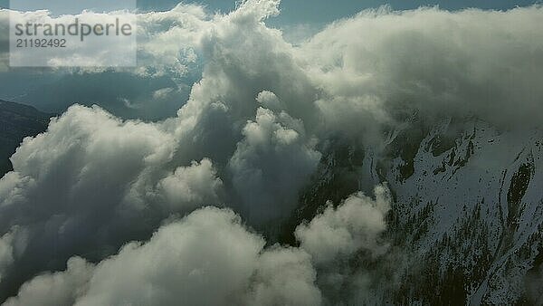 Fliegen durch schöne weiße flauschige Wolken zwischen hohen felsigen Bergen. Dolomiten Alpen Berge  Italien  Europa