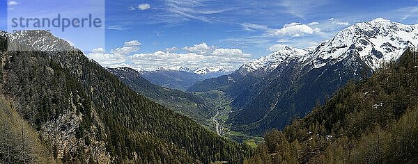 Beautiful top view panorama of high snow-covered mountains and valley with road and village in Switzerland at spring