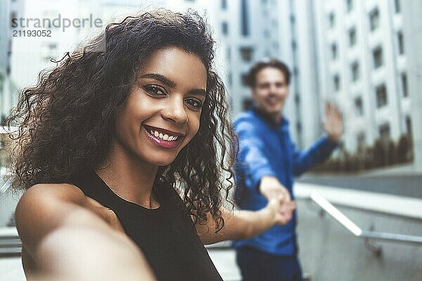 Outdoor portrait beautiful happy afroamerican woman taking selfie photograph smiling laughing with perfect teeth at street