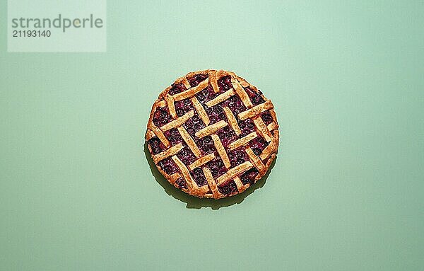 Home-baked cake with blueberries filling and lattice crust  top view. Flat lay with a delicious blueberry tart on a green background