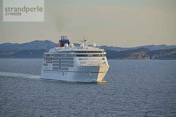 A cruise ship Europa 2 sails through the calm sea  surrounded by distant mountains  Bergen  Vestland  Norway  Europe