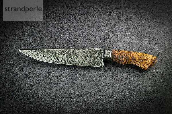 Beautiful luxurious utility knife in Texas Wind damask pattern with noble wood handle on dark background