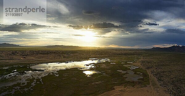 Aerial view of the sand dunes Elsen Tasarhai (Bayan Gobi) and lake at sunset in Mongolia