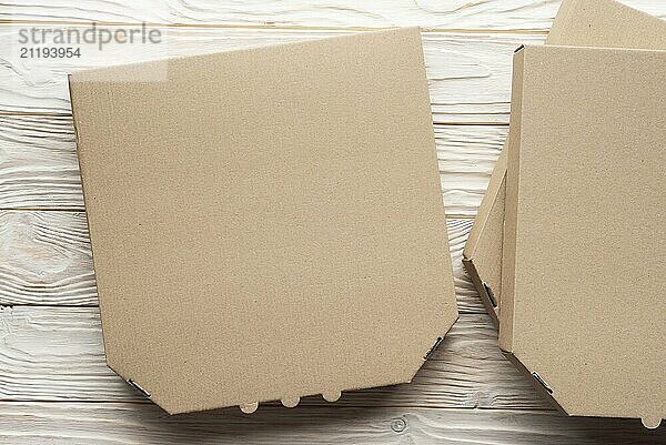 Pizza closed carton box on white wooden table flat lay mockup with blank space