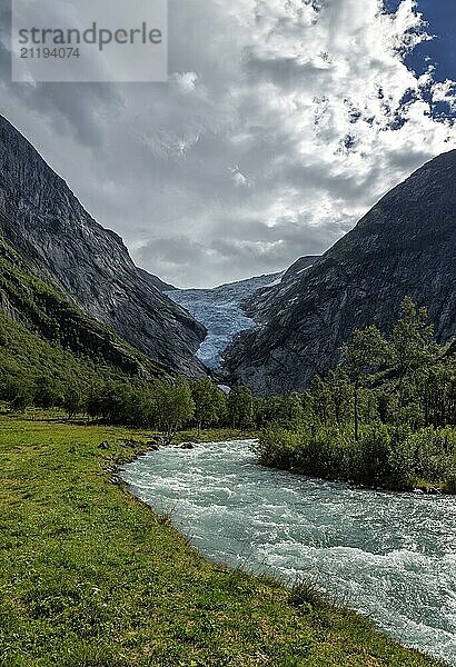 Panoramic view of the Briksdalsbreen glacier with meltwater flow in the foreground