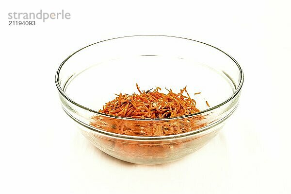 Grated carrot salad in a transparent bowl on a white background