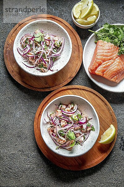 Food  Food  CHILEAN SALMON CEVICHE. Fresh raw salmon marinaded with purple onion  coriander in lemon juice. Sebiche and ingredientes on gray background. Top view