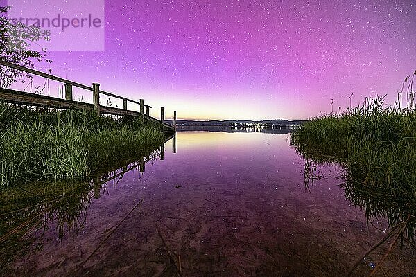 Blick auf einen ruhigen See mit rosa Himmel und Sternenhimmel mit Polarlichter  Aurora Borealis  Reichenau  Bodensee  Baden-Württemberg  Deutschland  Europa