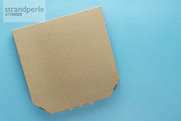 Pizza closed carton box on uniform blue background flat lay mockup with blank space