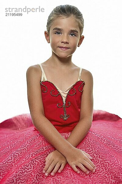 Portrait of a beautiful little ballerina in a performance red dress dreaming to become professional ballet dancer. isolated on the white background