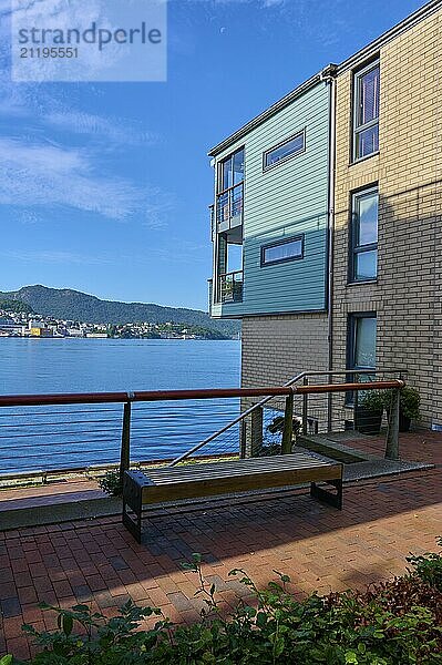 Modern residential building with several balconies and glass railings under a blue sky with clouds in a cityscape  Bergen  Vestland  Norway  Europe