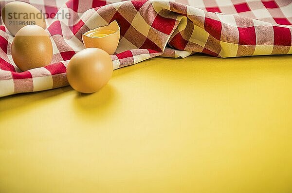 Beautiful fresh brown chicken eggs on yellow background with copy space