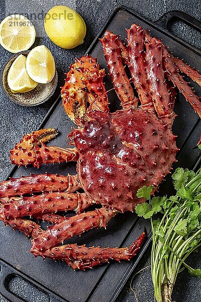 Food  Food  Red king crab on gray background. King crab  lemon and cilantro  top view