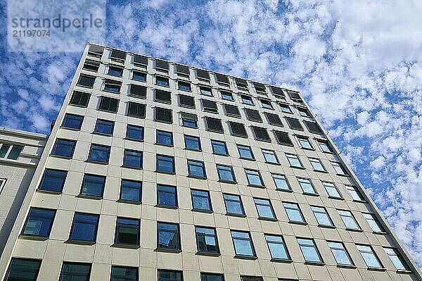 A modern skyscraper with many glass windows stands in front of a cloudy sky  Bergen  Vestland  Norway  Europe