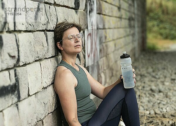 36 Jahre alte weiße Frau trinkt eine Flasche Wasser und entspannt sich nach dem Training  Brüssel  Belgien  Europa