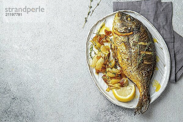 Food  Grilled sea bream or dorada on gray plate. Gray background