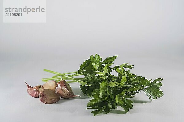 Garlic cloves isolated and parsley on white background